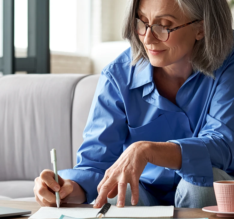 older woman writing down notes or list